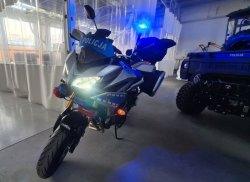 Na zdjęciu policyjny motor marki Yamaha Tracer 900 GT koloru srebrno-niebieskiego z napisami POLICJA.