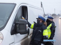 policjantki kontrolują trzeźwość zatrzymanego kierowcy białego busa przy pomocy alkomatu