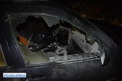 Na zdjęciu widać prawe przednie drzwi granatowego pojazdu z wybitą szybą. Przez otwór po wybitej szybie widać wnętrze pojazdu.