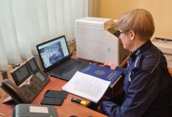 Na zdjęciu nadkomisarz Ewa Tuszyńska siedząca przed komputerem i rozmawiająca z uczestniczką spotkania online.