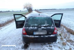 Na zdjęciu na ośnieżonej drodze szutrowej stoi pojazd koloru czarnego z otwartymi drzwiami od strony kierowcy i pasażera widok z tyłu auta.