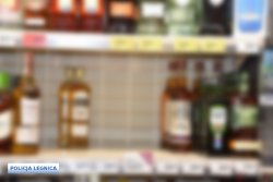 Na zdjęciu różnego rodzaju alkohole na dwóch półkach sklepowych.