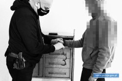 policjant zakłada kajdanki mężczyźnie