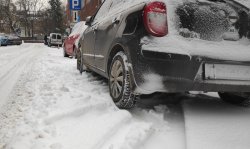 samochód osobowy zaparkowany na zaśnieżonej ulicy