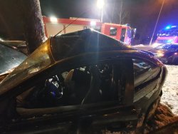 zniszczony w wypadku samochód osobowy a w tle służby ratownicze