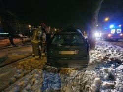 strażacy stoją koło samochodu osobowego który ucierpiał w wypadku samochodowym