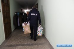 policjanci niosą paczki z odzieżą