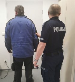 Zatrzymany mężczyzna stojący wraz z policjantem