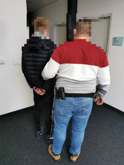 policjant z zatrzymanym mężczyzną