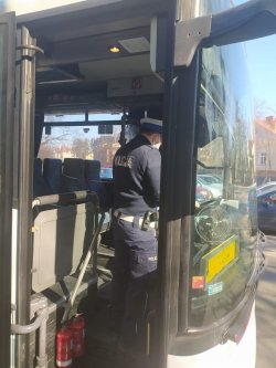 policjant rozmawia z kierowcą w autobusie