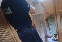 policjant w celi rozmawia ze stojącym mężczyzną