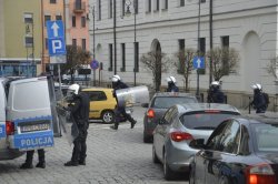 Policjanci stoją przy radiowozie.