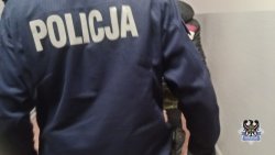 Na zdjęciu widać umundurowanego policjanta stojącego tyłem. W prawym dolnym roku widać emblemat wałbrzyskiej policji.