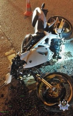 Zdjęcie przedstawia motocykl, który uczestniczył w wypadku. Leży rozbity na ulicy.