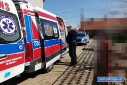 Na zdjęciu widać karetkę pogotowia i stojącego obok policjanta, w tle widać inne poajzdy