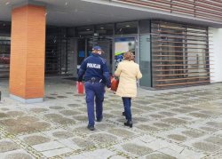 Na zdjęciu widać policjanta wchodzącego idącego na kontrol do budynku