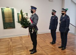 Na zdjęciu widać Komendanta Wojewódzkiego Policji we Wrocławiu oraz Naczelnika Wydziału Prezydialnego oraz policjanta składającego kwiaty pod tablicą pamiątkową