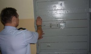 Policjant otwiera drzwi aresztu
