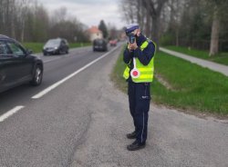 Policjant mierzy prędkość przejeżdżających samochodów