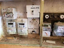 Na zdjęci widać tablicę z licznikami energii elektrycznej oraz &quot;korkami bezpieczeństwa&quot;.