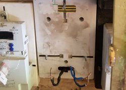 Na zdjęciu widać kable elektrycznej oraz fragment licznika energii elektrycznej we wnęce na ścianie.