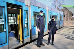 na zdjęciu widać umundurowanych policjantów, którzy zakończyli kontrolę obostrzeń w tramwaju