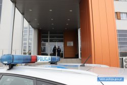 na zdjęciu widać radiowóz oraz policjantów wchodzących do hotelu celem dokonania kontroli