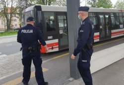 na zdjęciu widać dwóch policjantów, którzy udają się do autobusu aby dokonać kontroli