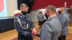 Komendant Wojewódzki Policji inspektor Dariusz Wesołowski wręcza pamiątkową legitymacje do medalu