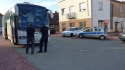 na zdjęciu widać autobus oraz kontrolujących dwóch policjantów