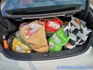 w bagażniku samochodowym torba plastikowa z zakupami  w postaci artykułów spożywczych