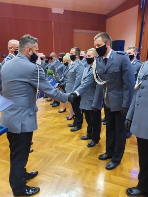 policjanci biorący udział w uroczystości obchodów święta policji, odbierają z rąk zastępcy komendanta akty mianowania, przemawiają