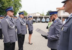 policjanci biorący udział w uroczystości obchodów święta policji, odbierają z rąk zastępcy komendanta akty mianowania, przemawiają