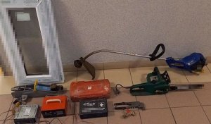 Zdjęcie przedstawia skradzione elektronarzędzia zabezpieczone przez policjantów, które leżą na podłodze.