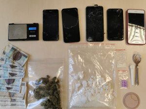zabezpieczone telefony, pieniadze i narkotyki poukładane na stole